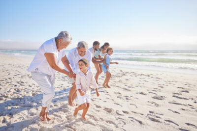 Grandparents playing with adorable grandson on beach