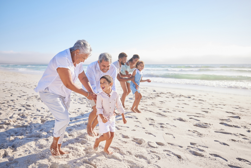 Grandparents playing with adorable grandson on beach